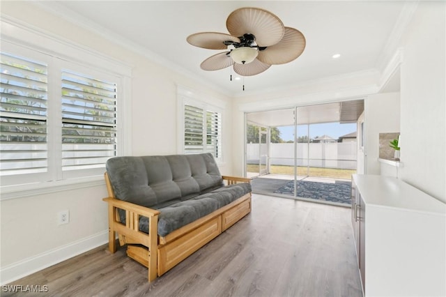 sitting room with ornamental molding, baseboards, and light wood finished floors