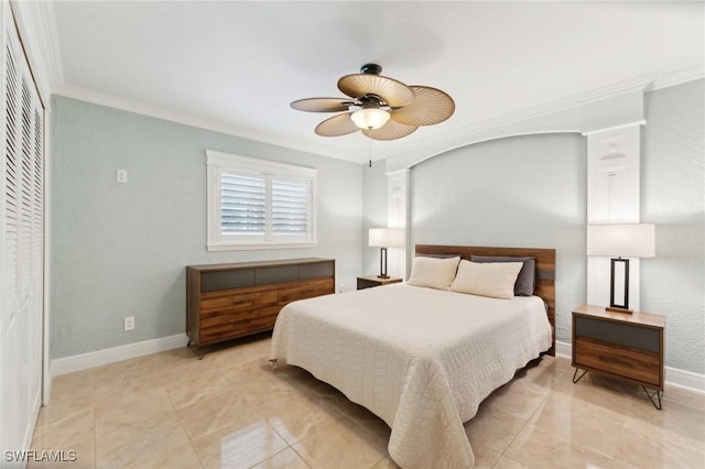 bedroom featuring a closet, crown molding, baseboards, and ceiling fan