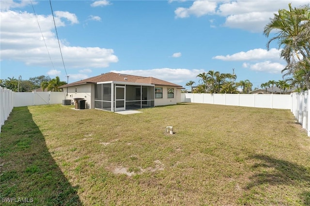 back of property with a yard, a fenced backyard, and a sunroom