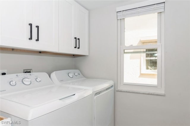 laundry room featuring washing machine and clothes dryer and cabinet space