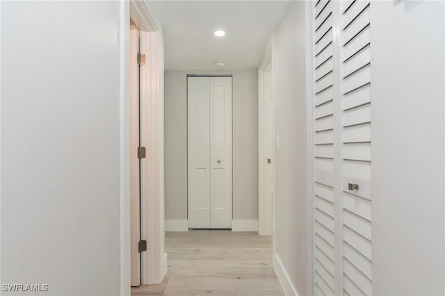 hallway featuring light wood finished floors, recessed lighting, and baseboards