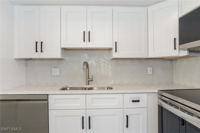 kitchen featuring decorative backsplash, appliances with stainless steel finishes, white cabinets, and a sink