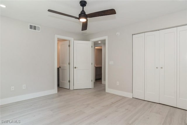 unfurnished bedroom with baseboards, a closet, visible vents, and light wood-style floors