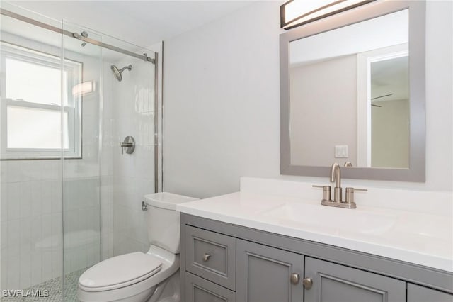 bathroom with a stall shower, vanity, and toilet