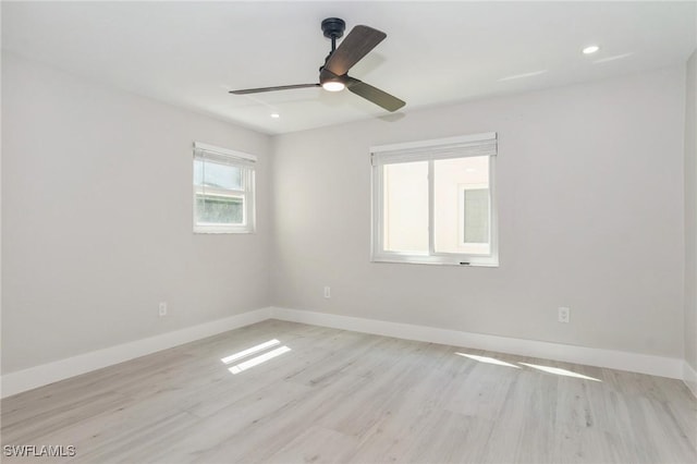 empty room with light wood-style floors, baseboards, and recessed lighting