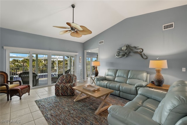 living room with a ceiling fan, lofted ceiling, visible vents, and light tile patterned flooring