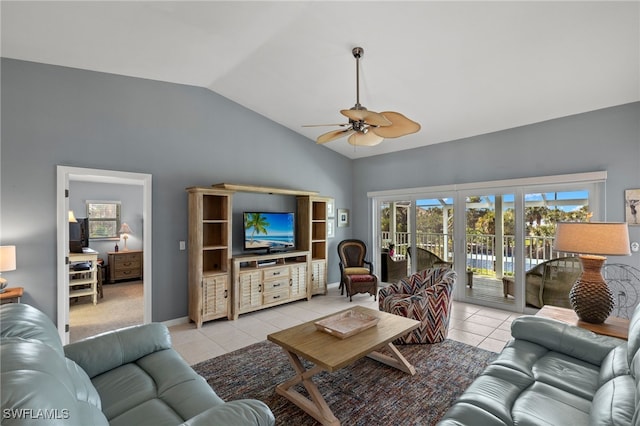 living area with a ceiling fan, vaulted ceiling, baseboards, and light tile patterned floors