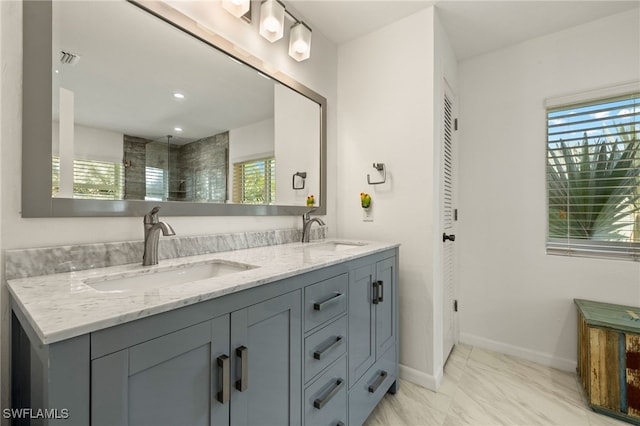 bathroom featuring double vanity, a closet, a sink, and baseboards