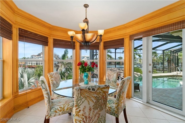 sunroom / solarium featuring a chandelier and a water view