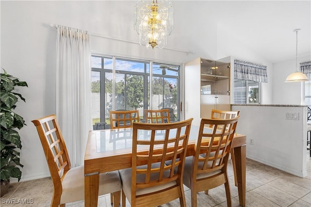 dining area featuring an inviting chandelier, light tile patterned floors, baseboards, and vaulted ceiling