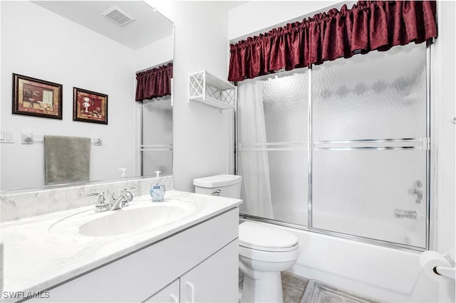 bathroom with toilet, bath / shower combo with glass door, vanity, and visible vents