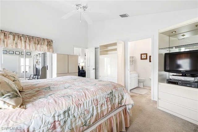 bedroom with light carpet, high vaulted ceiling, visible vents, and connected bathroom