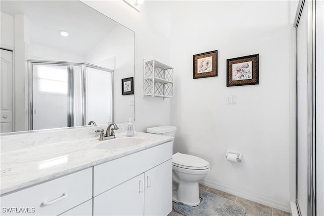 bathroom with toilet, a shower stall, vanity, baseboards, and tile patterned floors