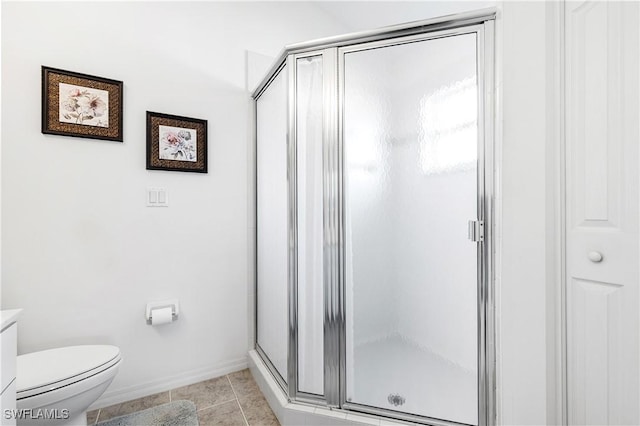 full bath with tile patterned flooring, baseboards, a shower stall, and toilet