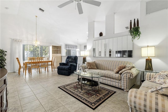 living room with light tile patterned flooring, a towering ceiling, and visible vents