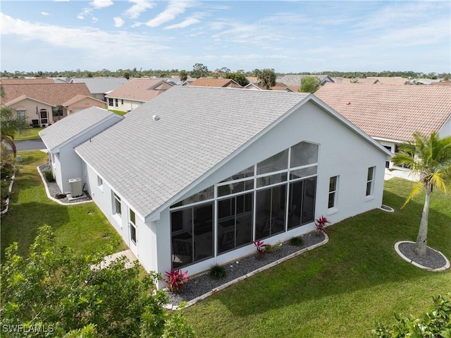 rear view of property with a residential view, a lawn, and stucco siding