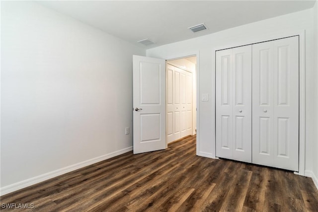 unfurnished bedroom featuring a closet, visible vents, dark wood finished floors, and baseboards