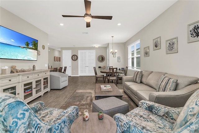 living area with recessed lighting, baseboards, visible vents, wood finished floors, and ceiling fan with notable chandelier