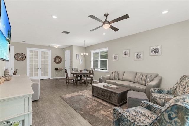 living room with visible vents, wood finished floors, ceiling fan with notable chandelier, french doors, and recessed lighting