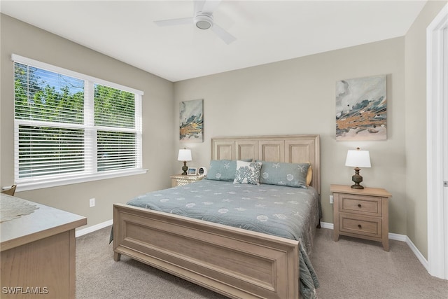 bedroom featuring ceiling fan, baseboards, and light colored carpet