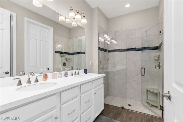 bathroom with double vanity, a stall shower, and a sink