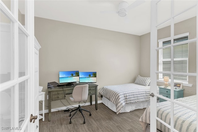 bedroom featuring a ceiling fan, wood tiled floor, and baseboards