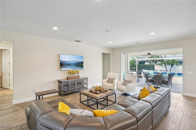living room with baseboards, recessed lighting, visible vents, and light wood-style floors