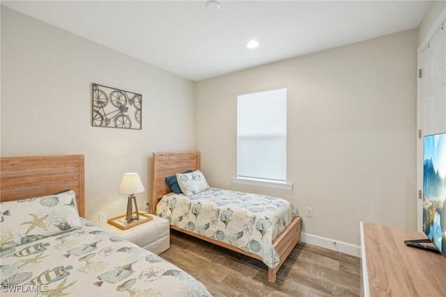 bedroom featuring baseboards and wood finished floors