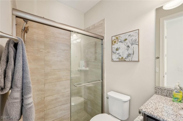 full bath featuring vanity, toilet, and a shower stall