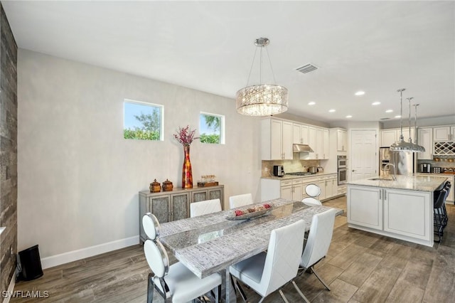 dining space featuring baseboards, visible vents, dark wood-type flooring, a chandelier, and recessed lighting