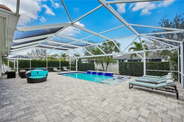 view of swimming pool with glass enclosure, a patio, a fenced backyard, an outdoor living space, and a fenced in pool