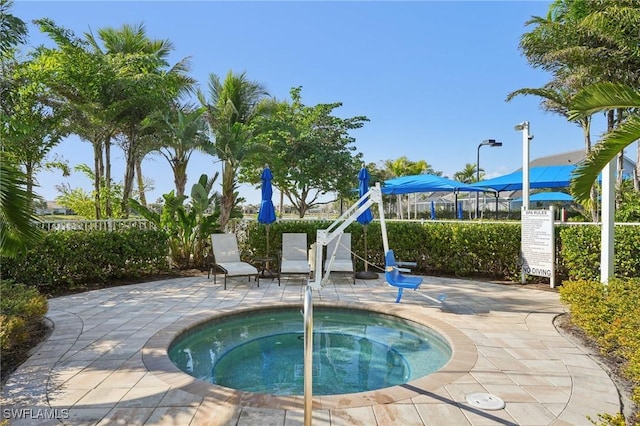 view of pool with a patio area, a hot tub, and fence