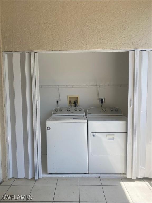 14801 Park Lake Dr Unit 203, Fort Myers, FL 33919 - laundry room featuring independent washer and dryer, a textured wall, light tile patterned flooring, and laundry area