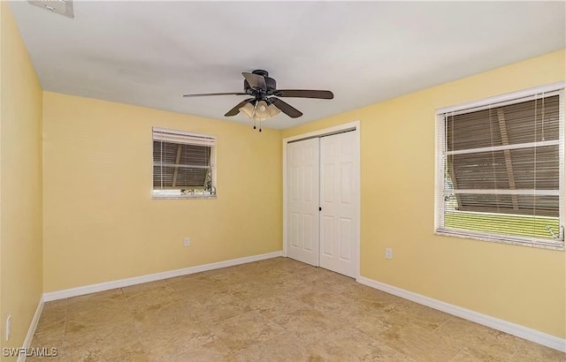 unfurnished bedroom featuring a ceiling fan, a closet, and baseboards