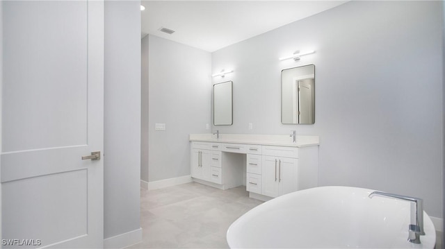 bathroom featuring double vanity, baseboards, visible vents, a soaking tub, and a sink