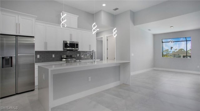 kitchen with decorative backsplash, appliances with stainless steel finishes, light countertops, white cabinetry, and a sink