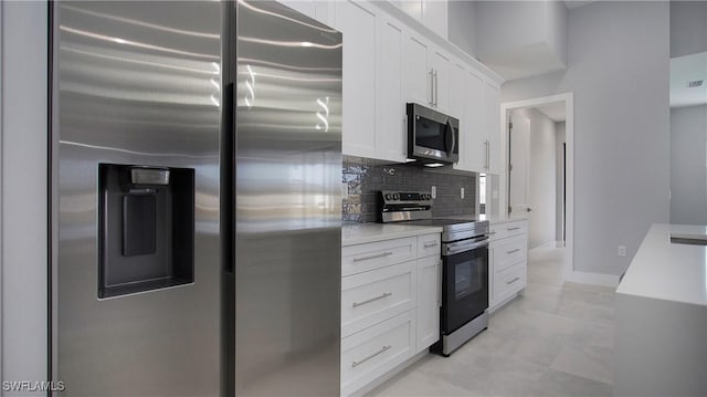 kitchen featuring stainless steel appliances, baseboards, white cabinets, light countertops, and tasteful backsplash