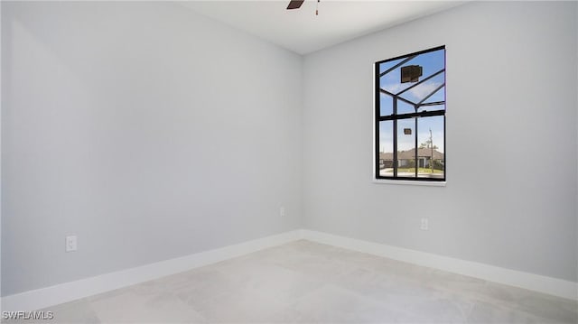 spare room featuring a ceiling fan and baseboards