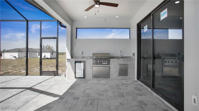 unfurnished sunroom with ceiling fan and a sink