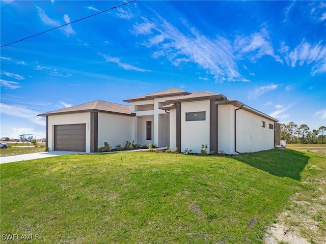 prairie-style home with a front lawn, driveway, an attached garage, and stucco siding