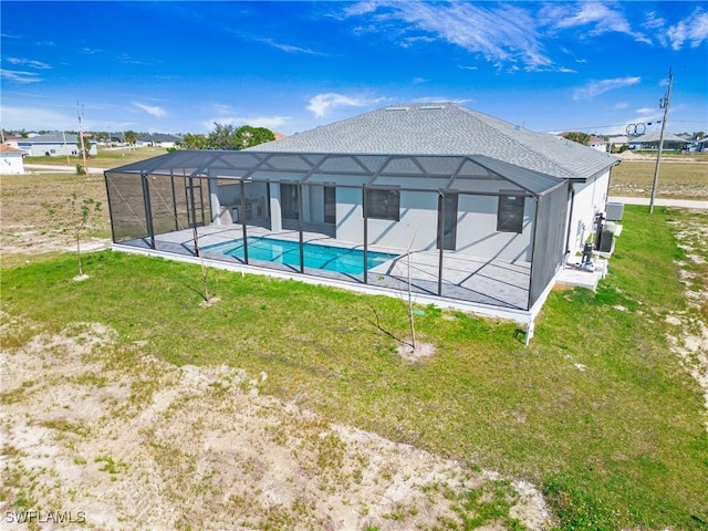 back of house featuring a lanai, an outdoor pool, and a yard