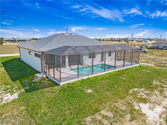 outdoor pool with glass enclosure, a patio, and a yard