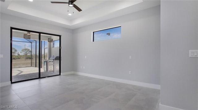 spare room with baseboards, a tray ceiling, a ceiling fan, and recessed lighting