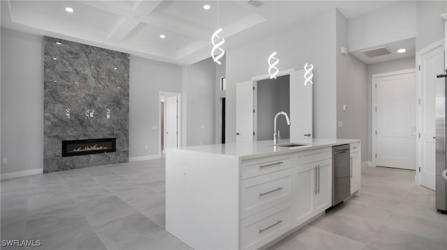 kitchen featuring a high ceiling, coffered ceiling, a sink, white cabinets, and stainless steel dishwasher