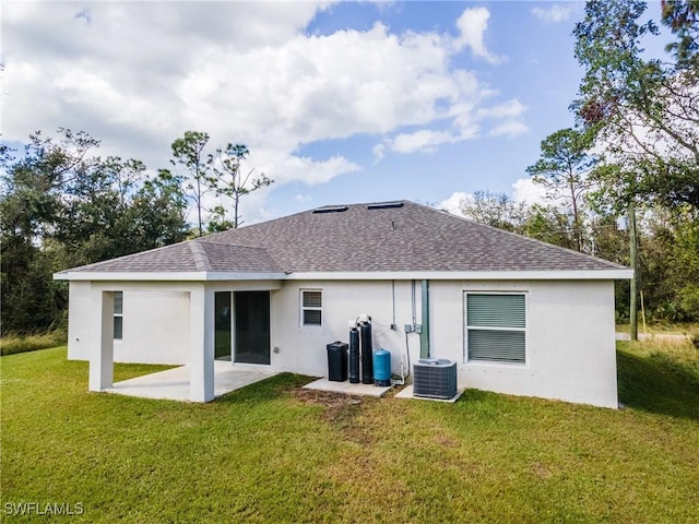 rear view of house featuring a yard, a shingled roof, a patio area, and cooling unit