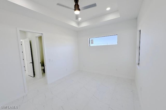 unfurnished room featuring ceiling fan, marble finish floor, a raised ceiling, and recessed lighting