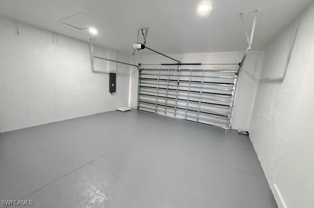 garage with a garage door opener, electric panel, and a textured wall