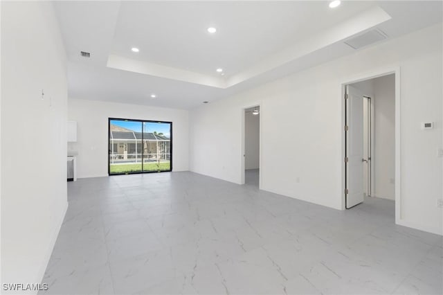 unfurnished room with marble finish floor, visible vents, a tray ceiling, and recessed lighting