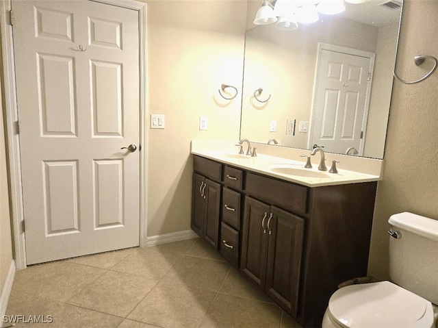 bathroom featuring double vanity, tile patterned flooring, a sink, and toilet