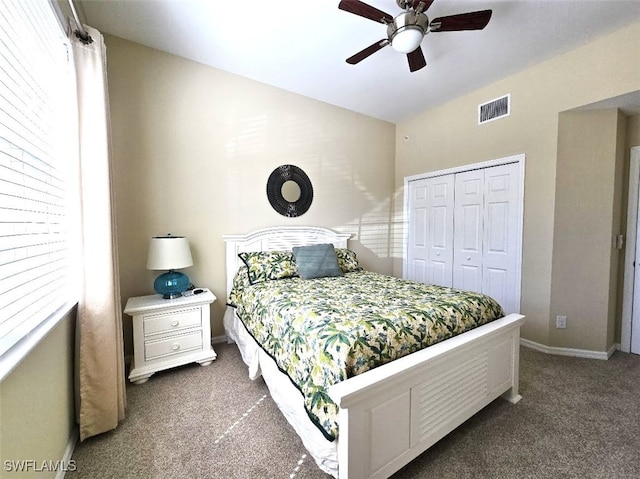 bedroom featuring baseboards, visible vents, lofted ceiling, dark carpet, and a closet